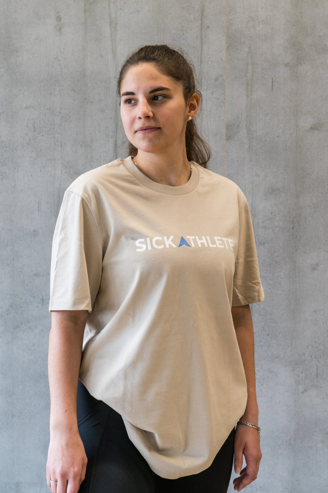 Sportlerin trägt das SICKATHLETE ESSENTIAL T-Shirt in der Farbe beige