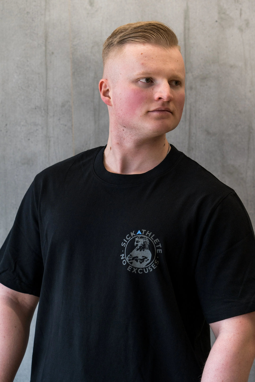 Bodybuilder trägt PURPOSE T-Shirt und schaut zur Seite